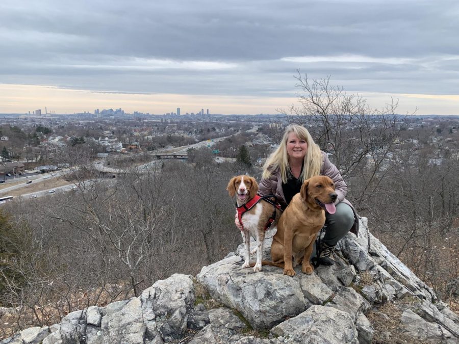 Science teacher Susan Vaughan poses with her dogs, Maggie, a red and white Brittany, and Rudy, a red lab, at Middlesex Fells Reservation in Medford.