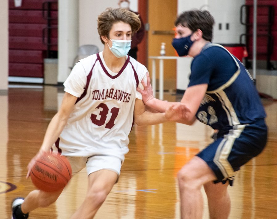 Freshman Andrew Eiben dribbles the ball past a defender during the JV2 basketball game against Shrewsbury on January 22.