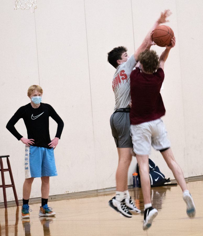 Thomas Zelnick watches Matthew Uzar block a shot from Joe Russell at sophomore basketball tryouts.
