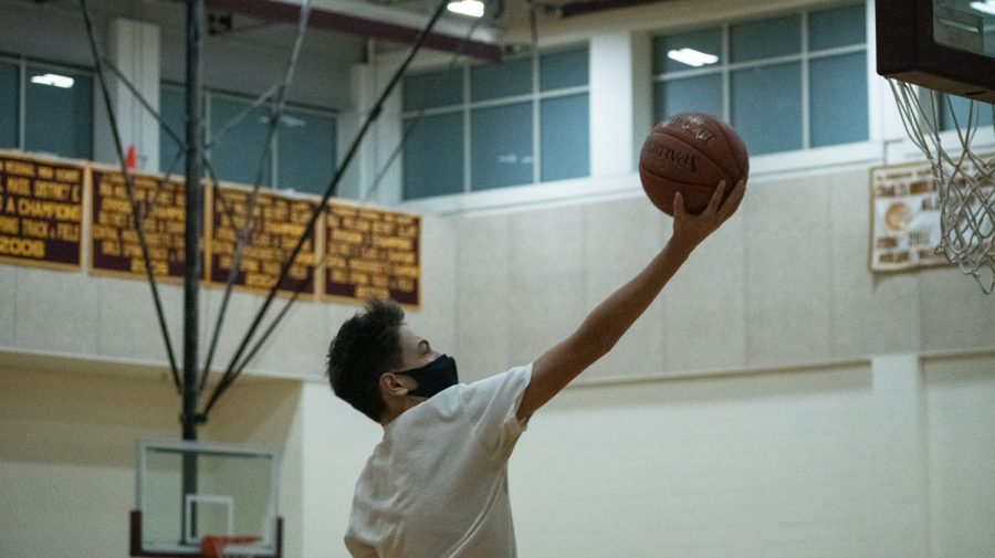 Christian Adriaansen goes for a layup during a half-court game at sophomore basketball tryouts.
