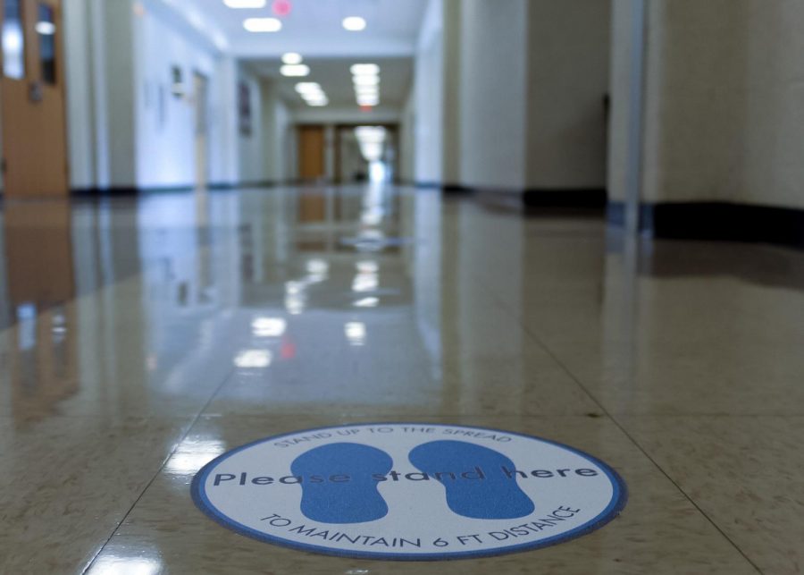 Markers placed on the floor in the hallway remind students and staff to stay socially distant, an implementation of one of the mitigation strategies put in place by the Medical Advisory Team.