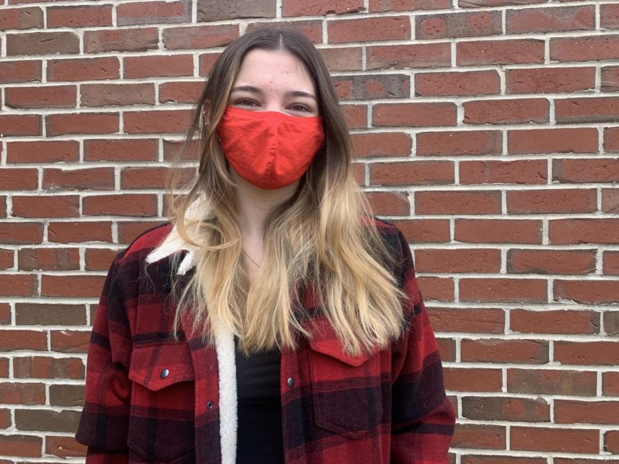 Assistant A&E Editor Jessie Lambert coordinates her red mask to a red striped jacket and shoes. 
