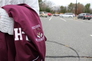 Senior Megan Harrington carries her soccer jacket displaying the tomahawk mascot, the subject of a petition calling for change written by Students for Justice”.