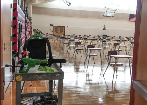 The C gym, which normally would house many enthusiastic gym students, is now filled with desks providing students with a place to eat lunch. The cart on the left shows some of the cleaning equipment used to frequently sanitize every area after students use it. 