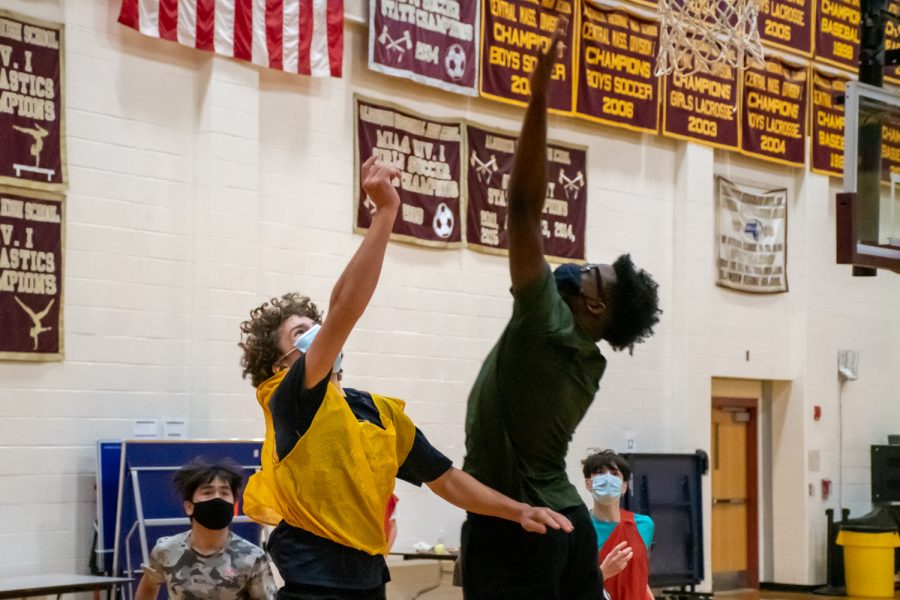 Freshmen Patrick Baimou and Brennan Rice both go up to get the ball from a rebound during the freshmen boys basketball tryouts on December 14. 