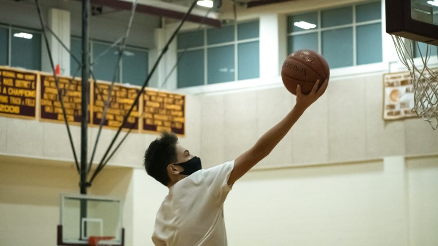 Sophomore Christian Adriaansen goes for a layup during a half-court game at sophomore boys basketball tryouts on December 16.