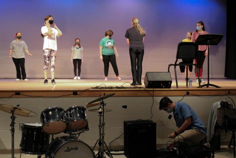 During a dance rehearsal, students work to learn the choreography while sophomore Ben Schanzer works with the tech crew to get the auditorium ready for the filming of the musical.
