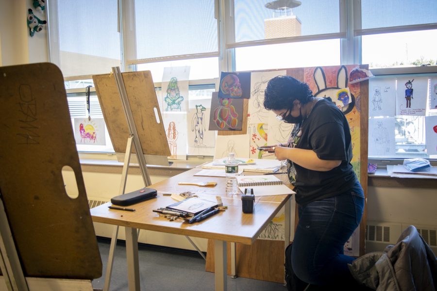 Senior Jasmine Castillo photographs her newly made artwork and later shows her friends.