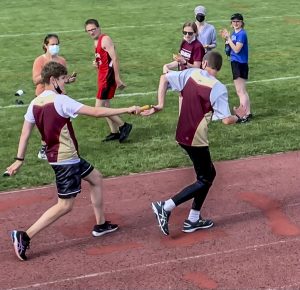 Junior Andreas Bello hands off the baton to Junior Tobin Moore in a relay event in the Unified Track meet against Hudson High School on Wednesday, June 2 at home. Moore has enjoyed meeting new people as part of the team, and said, “I hope to keep improving my scores.”