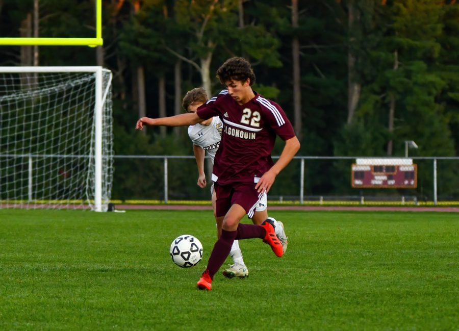 Trying to keep the ball from his opponent, sopomore David Downey runs down the field. Algonquin defeated Shrewsbury 3-0.
