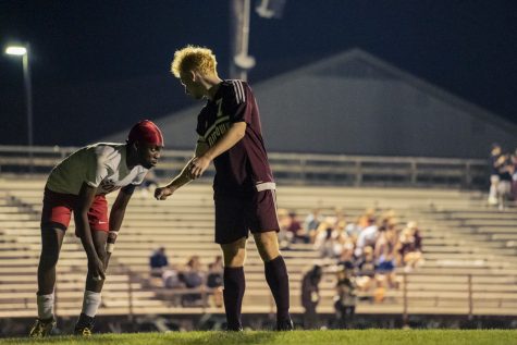 Senior Charlie Hynes reaches out to fist-bump a Worcester South player during the boys soccer game on Oct. 21. During the game, Hynes scored in double overtime, bringing the final score to 2-1.