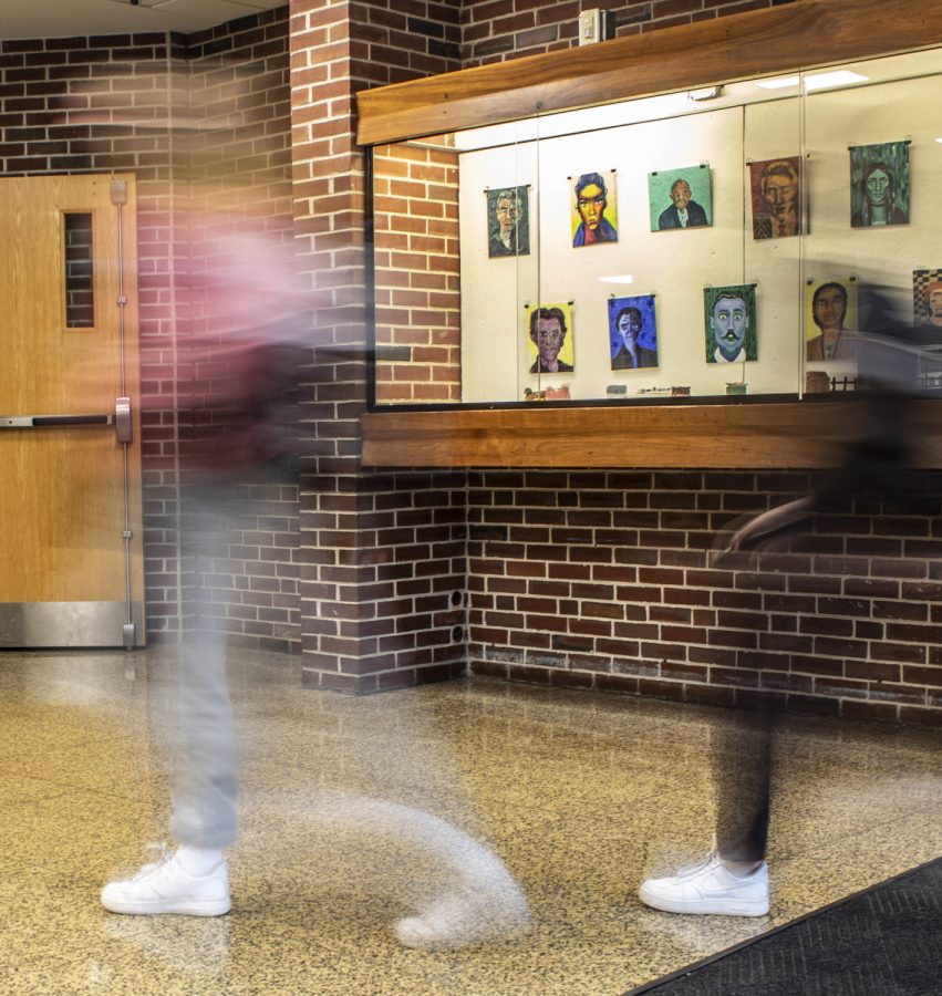 Students walk by the art case near one of the H200 stairwells. Last week, administration discovered that the underside of the case was covered with 15 years worth of graffiti. The graffiti has since been painted over.