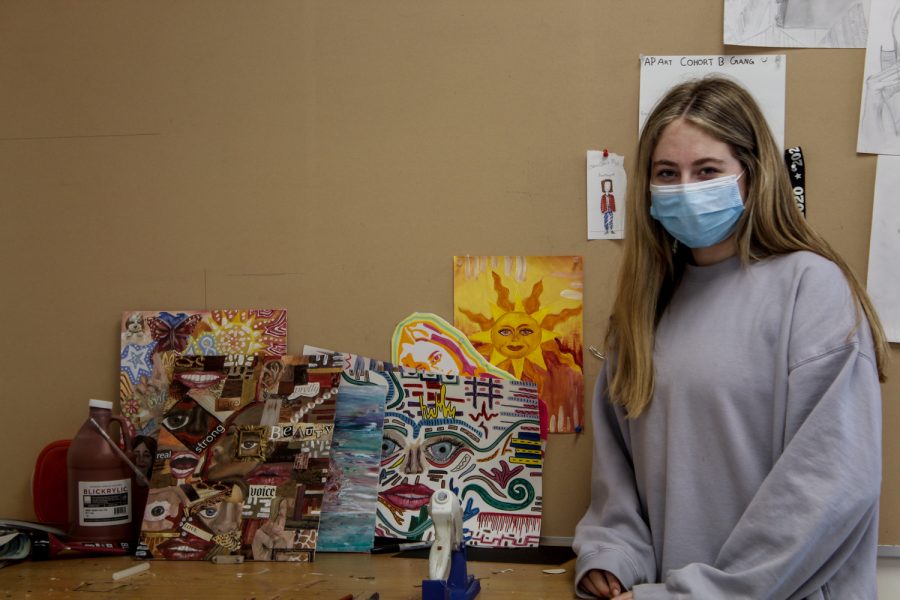 Senior, Eve Roiter, stands next to her Ap Art Cllass projects on Wednesday, Dec. 1, 2021.