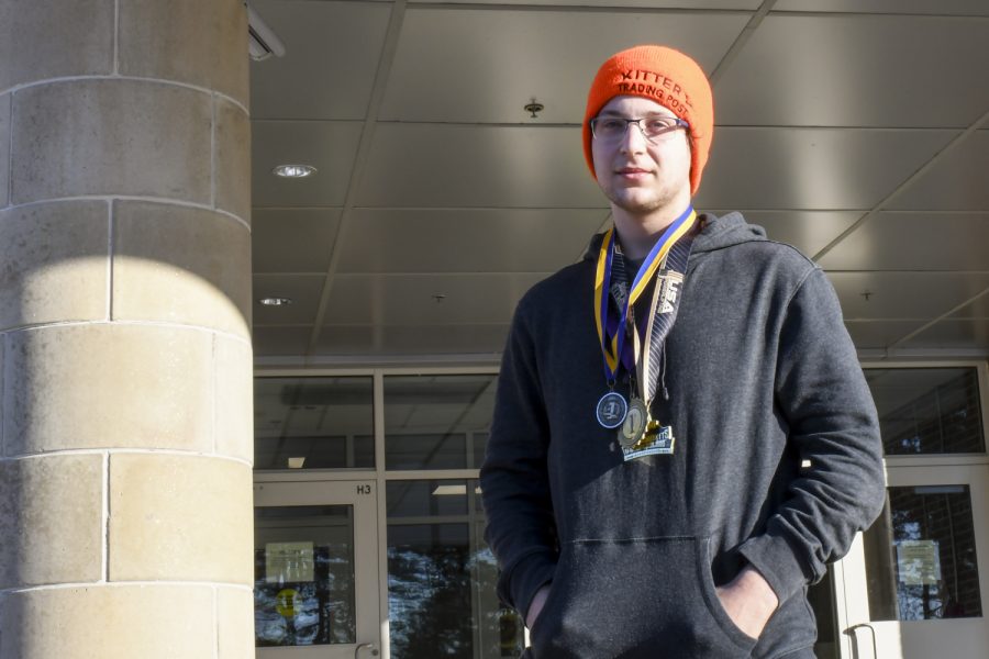Senior Ryan Weiner poses with his many weightlifting medals outside of school on Thursday, Dec. 9.