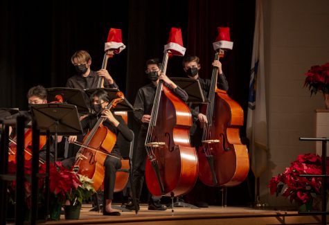Senior Connor Veitch, sophomore Elliot Yee and senior Reed Probst play the string bass in Full Orchestra during the Holiday Concert on Tuesday, Dec. 21.