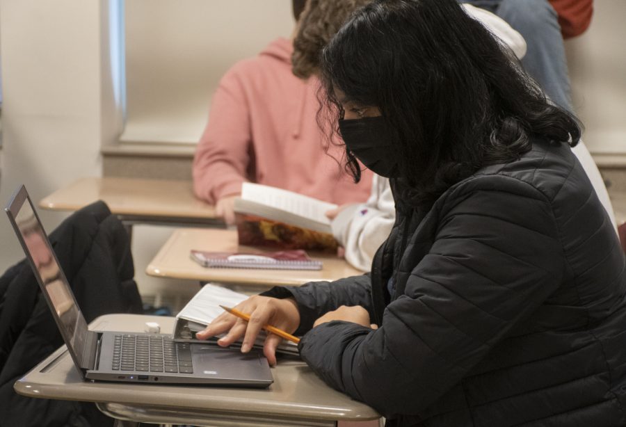 Sophomore Priya Maraliga looks at notes on her computer while taking notes on an index card on Jan. 14, 2022. Midterms are occuring at Algonquin leading students to study the material from the first two terms.