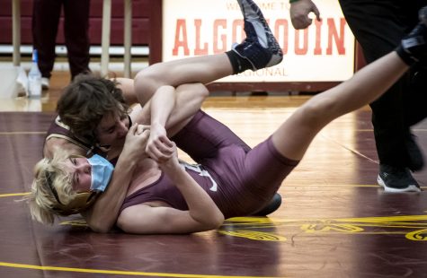 Freshman Garret Willwerth fights against a Shepherd Hill competitor at the wrestling match on Dec. 22, 2021.