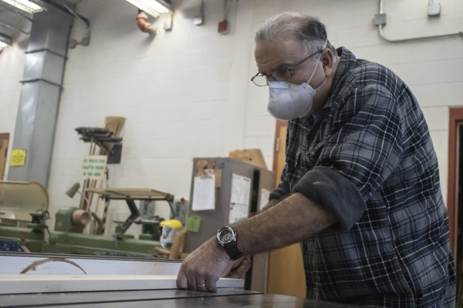 Applied Arts teacher Ralph Arabian cutting a plank of wood on a table saw. Arabian will be teaching a new class called Hands-On Engineering.