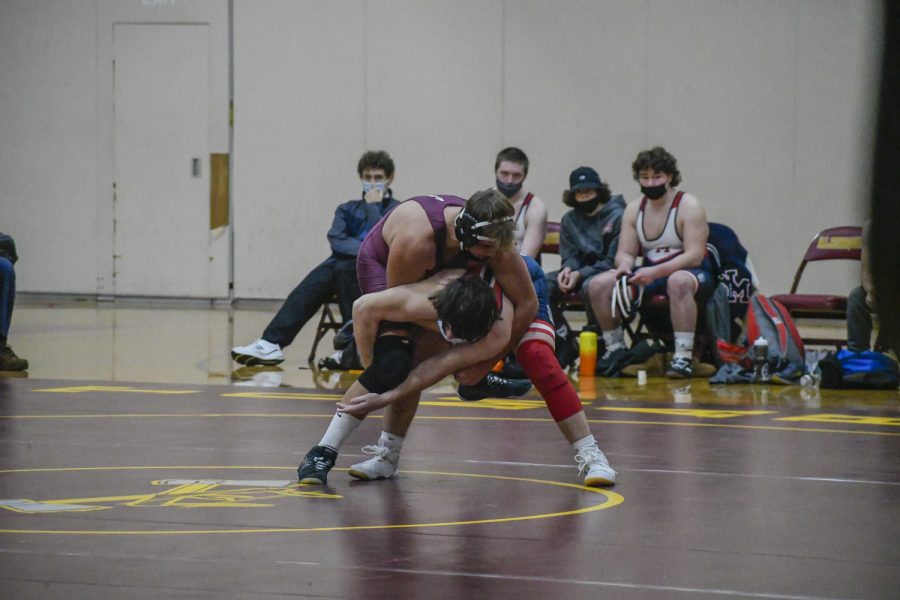 Sophomore Adam Ayzenshtat attempts to pin his opponent during the wrestling match on Jan. 12, 2022.