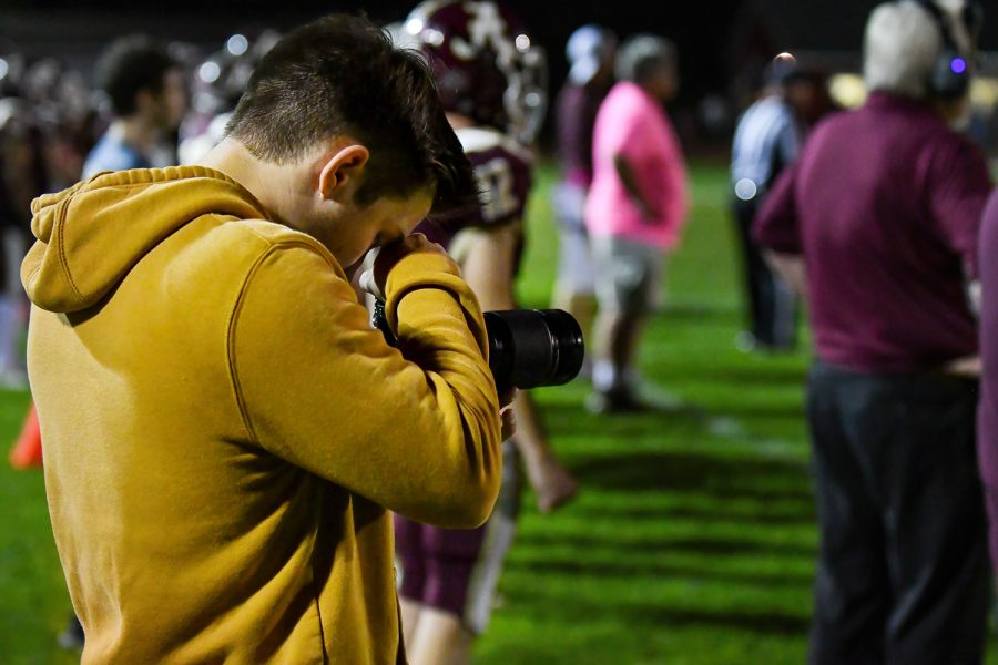 Senior Dan Root shoots a video at a football game. Root enjoys filming and producing videos of various sports games. 