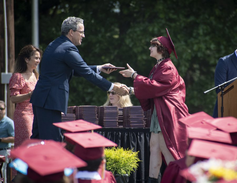 Principal Sean Bevan hands students their diplomas as their names are called.