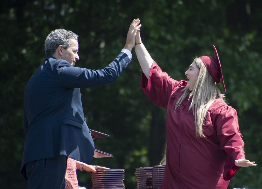 Stella Deluty gives Principal Sean Bevan a high-five as she recives her diploma.