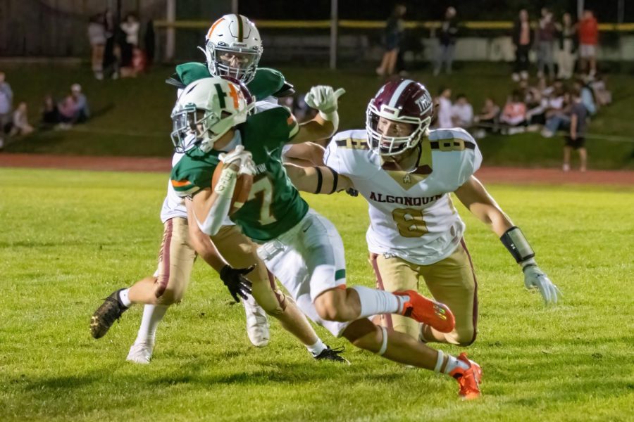 Senior Matt Uzar tries to take the ball from a Hopkinton High School football player. Algonquin competed in a game against Hopkinton High School on September 16 and lost 18-22.