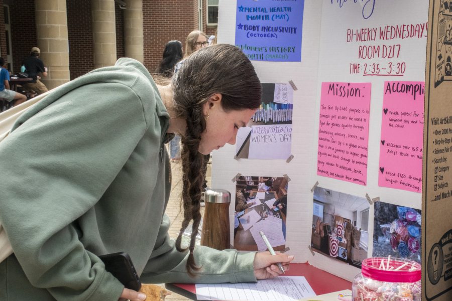 A student writes down their name and contact information in order to join the Girl Up Club during the Activities Extravaganza on Wednesday, September 21.