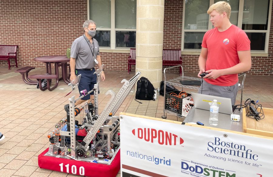 At the Extracurricular Extravaganza held on Sept. 21, senior Cam Jackson pilots the robot that he built in the Algonquin Robotics Club. This robot was designed to represent Algonquin in a competition with other schools by shooting basketballs into a hoop.