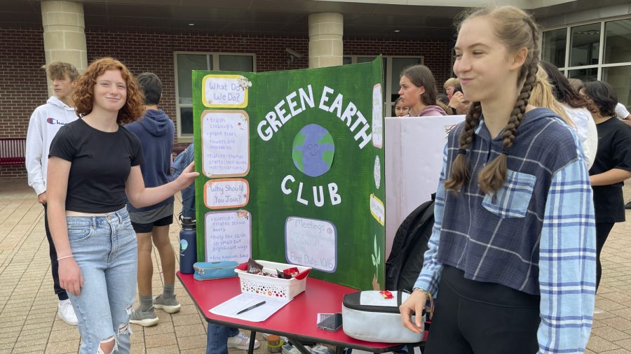 Seniors Lee Gould(Left) and Elle Westphal entice people to learn more about the Green Earth Club with a bucket of candy during the Activities Extravaganza held during all three lunches on Wednesday, Sept. 21, 2022.