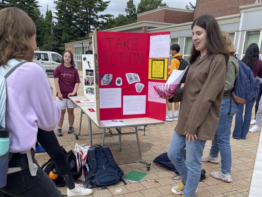 A student representing the Take Action club passes out candy during the Activities Extravaganza held during all three lunches on Wednesday, Sept. 21, 2022.