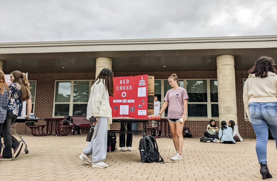 The Activities Extravaganza, held on Sept. 21, includes booths such as the Red Cross Club, which senior Elizabeth Reynolds talks to her peers about.
