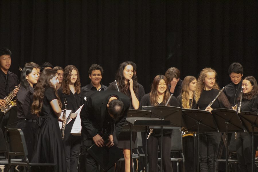 Fine and Performing Arts teacher Eric Vincent takes a bow as he stands with student musicians at the Fall Instrumental Concert on Nov. 2, 2022.