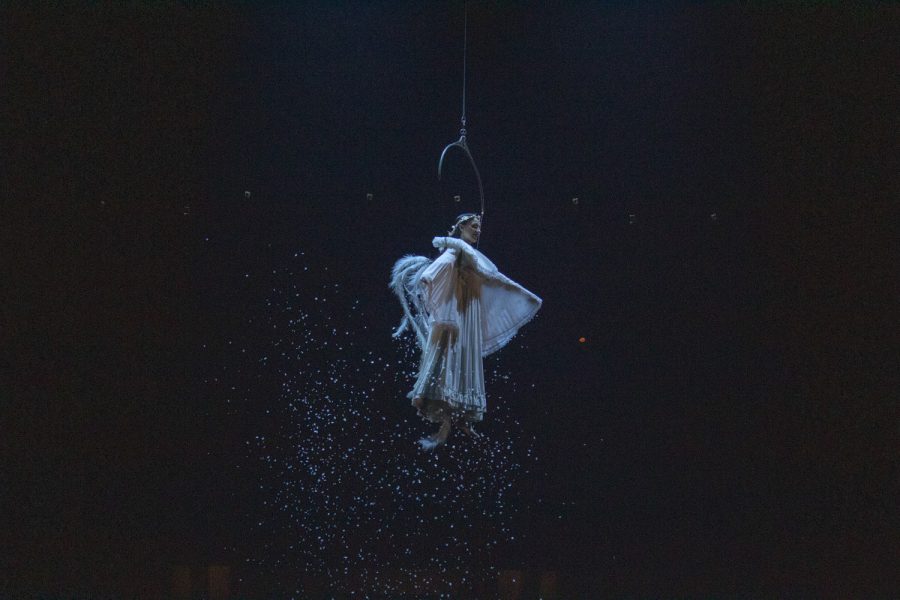 An angel flies above, spreading glitter on to the stage below in an act for Cirque du Soleil at the Worcester DCU Center.