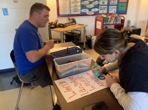 Spanish Honor Society members senior Sonya Libman and junior Matthew Carreras make posters for World Language Week in Spanish teacher Evan Greenwalds room on April 13 as part of the societys service requirement.