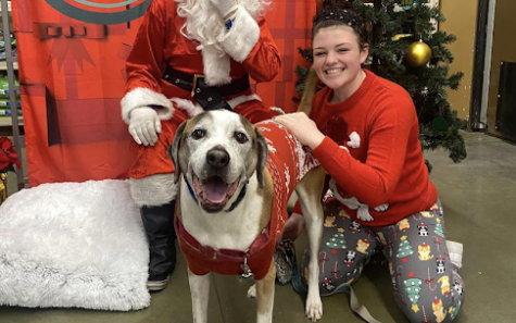 Senior Audrey Richardson poses with a dog next to Santa. Richardson started a pet sitting business to pursue her passion for taking care of animals.