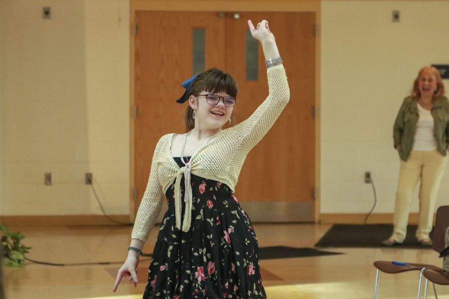 Sophomore Catherine Campbell strikes a pose towards the audience at the end of the runway during the Inclusive DECA fashion show on March 30, 2023.