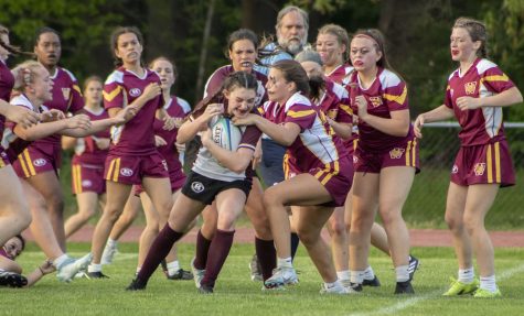 During the girl’s rugby game on May 12, junior Eleni Chacharone pushes through opposing players to score a try. Algonquin beat Weymouth 19-5.
