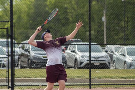 Senior Cam Jackson lines up to serve during the boys tennis match on May 19.