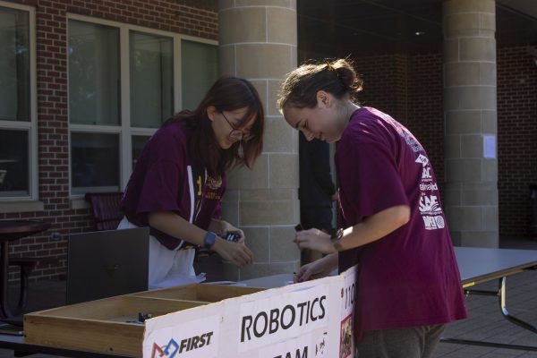 Senior Autumn Stewart and sophomore Anthea Sun set up the Robotics Club display for the Activity Extravaganza on Sept. 21. Students attended the event during all three lunches, which features clubs and extracurricular activities.
