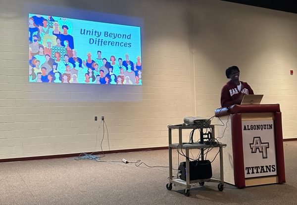 Unity Beyond Differences founder, senior Patrick Biamou, leads a club meeting in the Black Box Theater after school on Sept. 14.