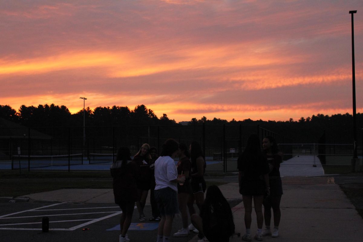 Students talk and take photos as the sun rises on Sept. 8.