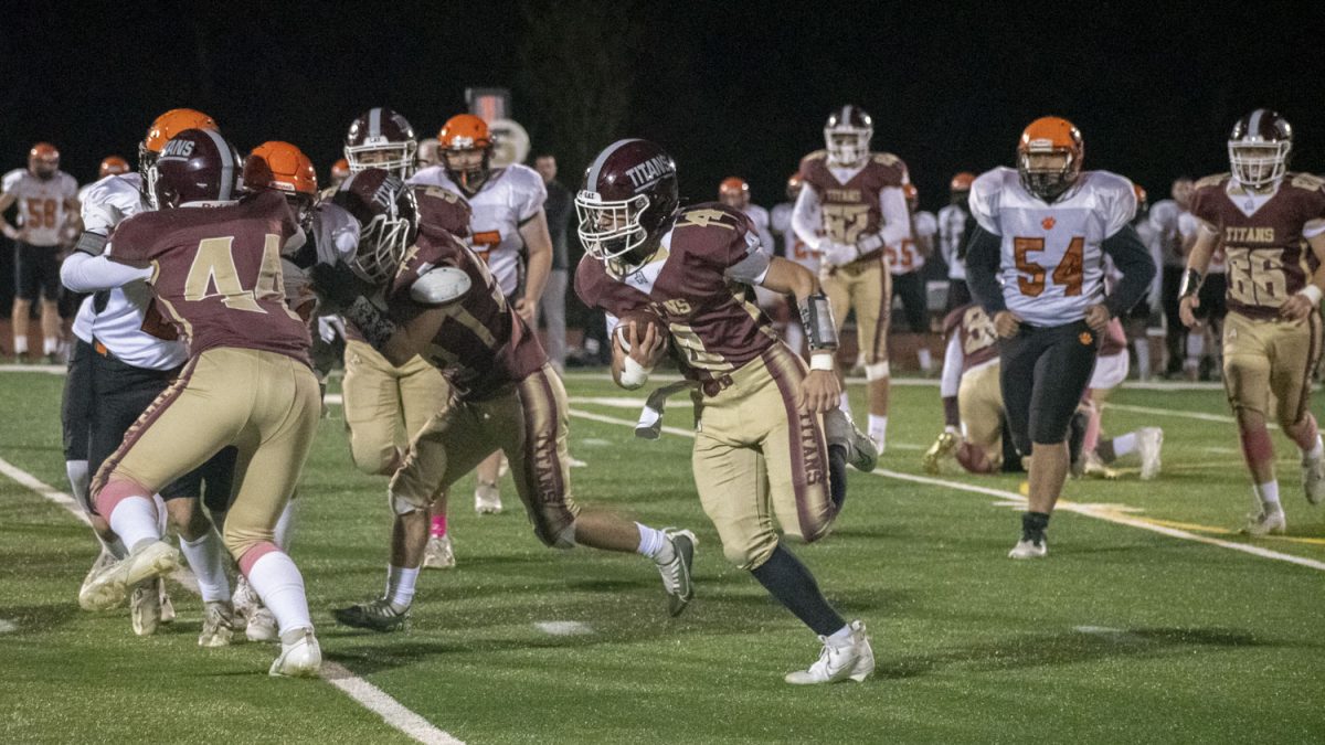Junior quarterback Liam Snyder carries the ball down the field as teammates block Marlborough defenders during the Football game on Oct. 14. The game was played at Shrewsbury High School.