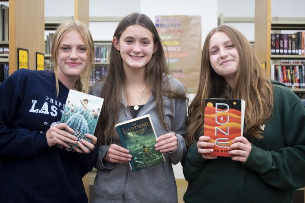 Juniors and Page Turners Book Club leaders Claire Wikander (left), Laney Halsey (middle) and Sophie Kopstein (right) hold books they have recently read.