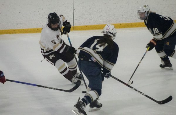Sophomore Brenna Joyce dodges opponents during the third period of the girls hockey game against Acton-Boxborough on Dec. 18, 2023. Algonquin won 4-0.