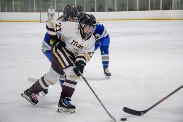 The girls hockey team won 6-0 against Auburn during their first Division II playoff game at the New England Sports Center on Feb. 29. Junior Annie Biagini (21) defends the puck while moving towards Auburns goal.