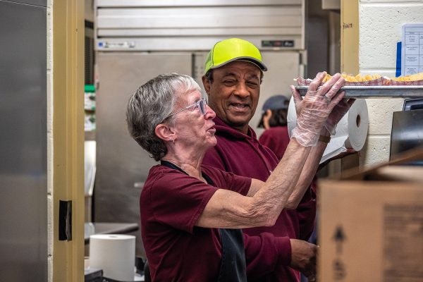 Cafeteria staff Betsy Swallow and retired custodian John Souza prepare for first lunch on Dec. 1.