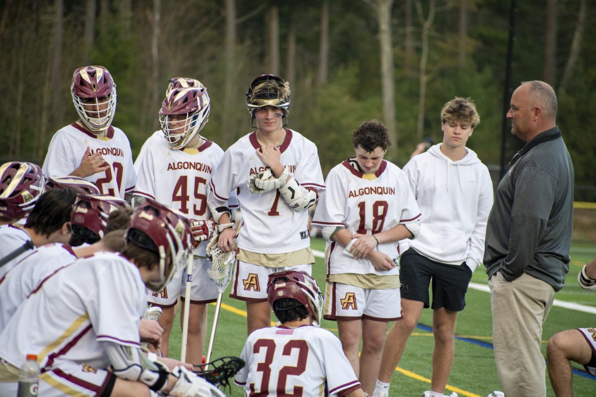 New boys lacrosse coach Mark Kelley talks with the team during a timeout at their game on May 2, 2024.
