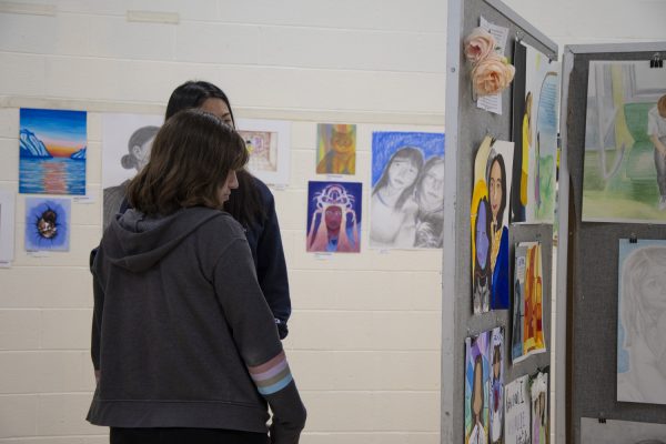 Sophomores Jersey Malcolm (front) and Sophia Shen (back) look at the art during the Art Show on May 16. The Art Show showcases artists from the 2023-2024 year at Algonquin, incorporating work from students in Photo 1 and 2, Photojournalism, AP Art, Ceramics 1 and 2, and more.