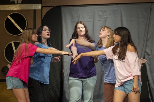 From left to right: sophomore Ty Moran, juniors Audrey McManus and Maggie OConnell, and seniors Savannah Staples and Juliana Oyola act out a sketch of pre-teen girls in a Sephora, huddling together after creating their game plan during Improv Night on May 16.